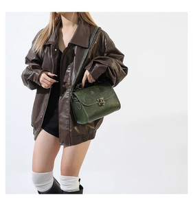 Detailed view of vintage dark green PU leather handbag with floral embossing and bronze lock