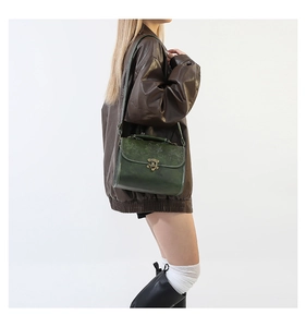 Detail showing vintage dark green faux leather handbag with embossed lotus floral pattern