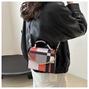 Detail of color-block patchwork bag featuring gold chain and smooth PU leather finish