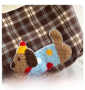 Detail of coffee plaid handbag featuring a 3D plush puppy embroidery and Romantic Time text
