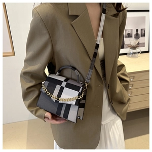 Model view of a luxury checkered crossbody bag with gold chain and wide shoulder strap