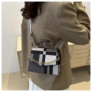 Style shot of plaid crossbody bag with gold chain and slim strap on model