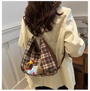 Detail of checkered crossbody bag featuring a cute dog embroidery and leather strap