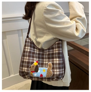 Brown plaid hobo bag detail with a cute dog patch embroidery on soft checkered fabric
