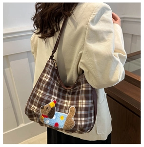 Detail of a brown plaid hobo bag featuring a cute cartoon puppy embroidery patch