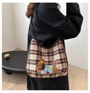 Close-up of retro plaid crossbody bag featuring a cute teddy dog embroidery patch