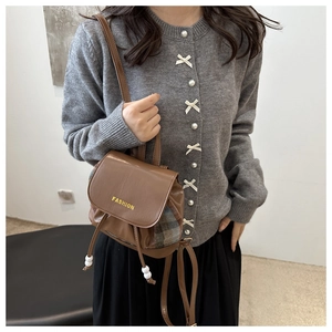 Detail of brown leather mini backpack with checkered panels and fashion lettering