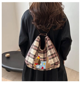 Detailed close-up of a checkered tote bag featuring a cute embroidered puppy on the back
