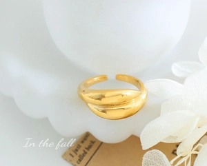 Detailed close-up of a polished gold minimalist ring on an elegant white pedestal