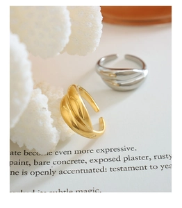 Detail of gold and silver open rings with twisted texture and smooth metallic finish