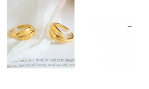 Detail of two adjustable gold stacked rings on white silk fabric showing glossy finish