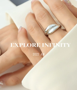Macro detail of silver polished wavy ring with minimalist curved design on model's hand