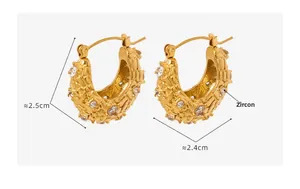Détail de créoles dorées à texture rocheuse serties de zircons cubiques brillants