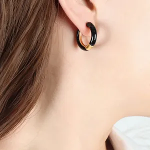Minimalist C-shaped bicolor hoop earrings with black enamel and gold plating detail