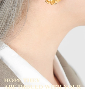 Détail de boucles d'oreilles vintage dorées avec grappes de zircons portées par un mannequin