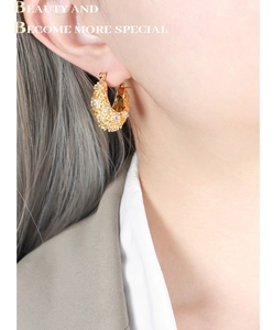 Détails de boucles d'oreilles créoles dorées vintage serties de zircons sur mannequin