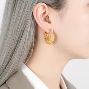 Boucles d'oreilles vintage dorées en C avec zircon et relief texturé sur mannequin