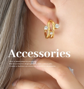 Detail of vintage gold C-shape earrings with liquid texture and inlaid zircons