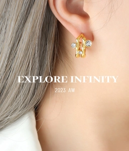 Close-up of gold hollow earrings with cubic zirconia on a model for the 2023 AW collection