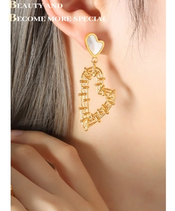 Detailed view of elegant gold hollow heart earrings with white shell studs on a model