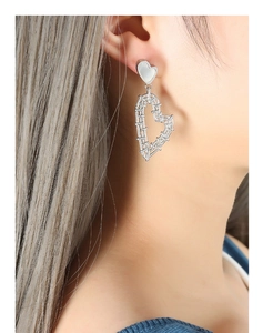 Macro detail of the woven hollow heart design and iridescent shell inlay on earring