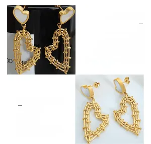 Detail of 18K gold plated heart earrings with woven texture and white shell inlay