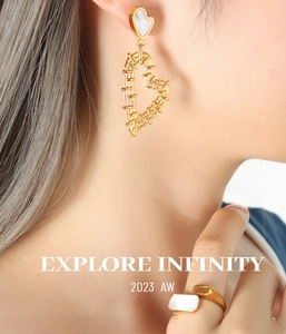 Detail of gold heart earrings with white shell inlay and matching open shell ring