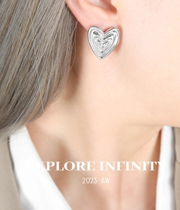 Close-up of layered heart earrings in silver finish showing detailed wavy texture