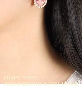 Close-up of vintage pink oval cameo earrings with delicate faux pearl border on model