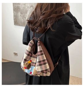Detail view of British plaid canvas backpack with leather straps and bear embroidery