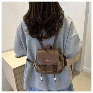Detail of checkered patchwork mini backpack with gold fashion lettering and pearl accents