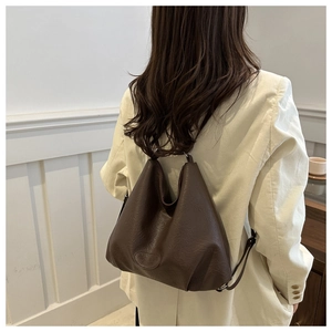 Detail of dark brown tote bag showing supple leather texture and brand embossing