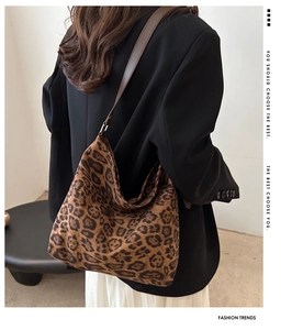 Leopard print hobo bag with dark brown strap shown from a side view on a model