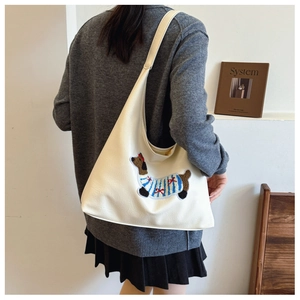 Dettaglio della borsa tote in pelle PU crema con ricamo decorativo a forma di bassotto
