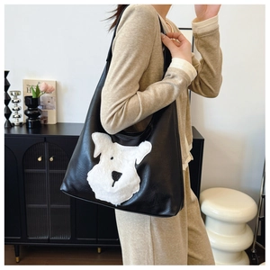 Dettaglio della borsa tote in pelle PU nera con ricamo patchwork a forma di cucciolo