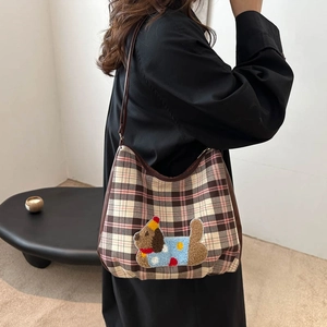 Classic plaid hobo bag with cartoon puppy embroidery shown on model for a trendy daily look
