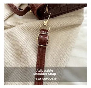 Détail de la bandoulière marron motif crocodile avec boucle réglable en métal doré