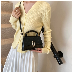 Détail du sac noir à motif crocodile avec boucle en U dorée et texture en cuir PU chic