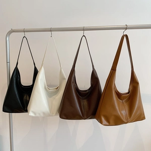 Minimalist large capacity leather shoulder bags in four colors on a metal stand