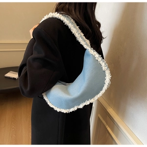 Détail du sac bandoulière en demi-lune bleu clair avec bordure en fourrure blanche