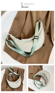 Detail view of the light green crescent crossbody bag with adjustable nylon strap