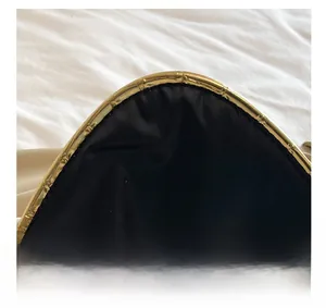 Detail shot of black envelope clutch with gold metal trim and easy opening design