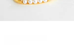 Macro detail of U-shaped gold earrings with five pearls and feature descriptions