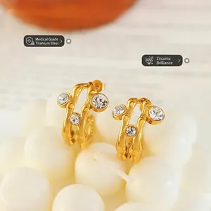 Golden titanium steel hoop earrings with wave texture and sparkling cubic zirconia