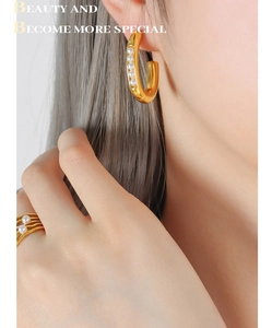 Close-up of French style C-shaped pearl earrings and multi-layer wave pearl ring on model