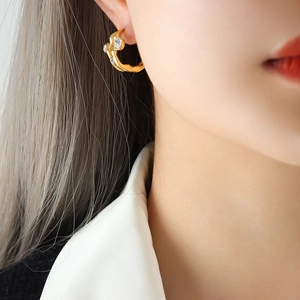 Modern gold hollow geometric earrings with lava texture and zircon stones on model