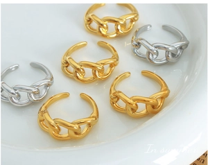 Detail of chunky chain link rings in gold and silver finish with adjustable open design