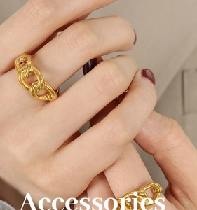 Macro detail of high-polish chain link rings plated in 18K gold on model's hand