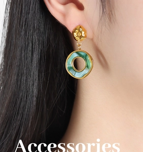 Detail of 18K gold geometric earrings with green marble resin drop on model ear
