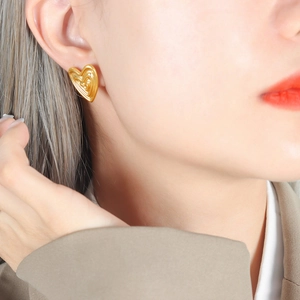 18K gold heart stud earrings featuring a unique multi-layered ripple texture on model